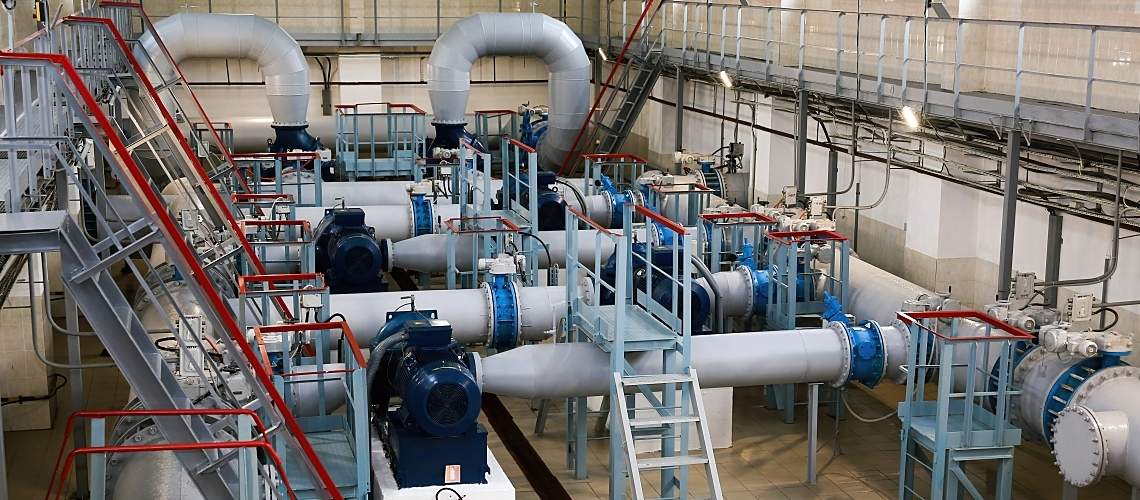 An industrial water pumping station with pumps, pipes, and valves.