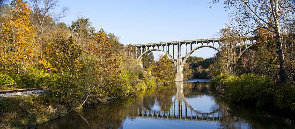 A bridge reflected in the Cuyahoga River in Ohio on an autumn day.