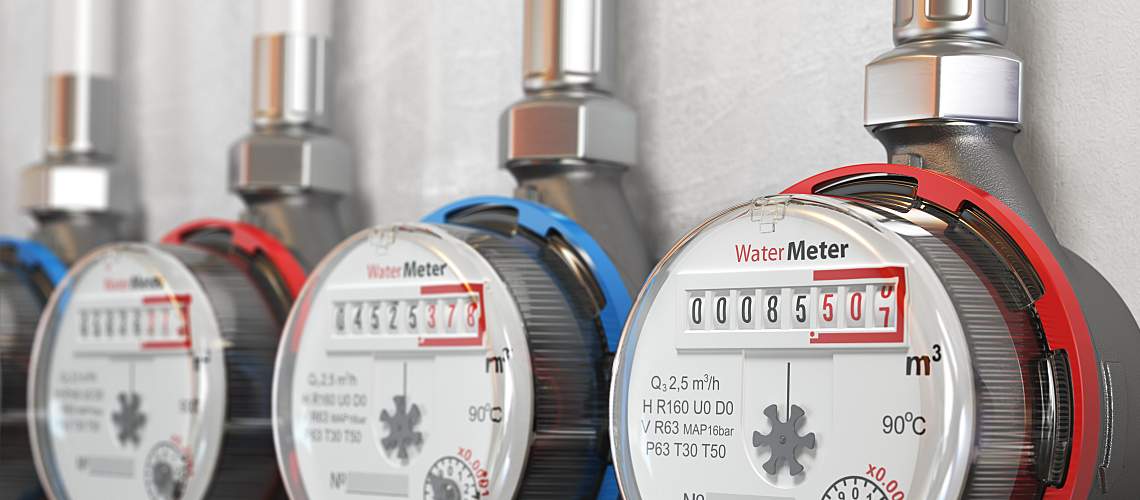 Row of water meters of cold and hot water on a wall.