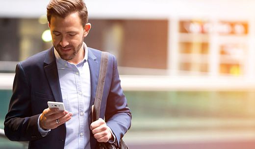 Young attractive man looking at his smart phone in a public area