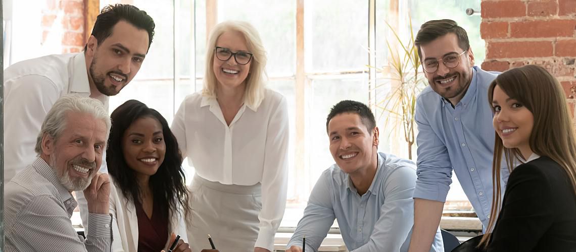 Multi generational employees sitting around a table.