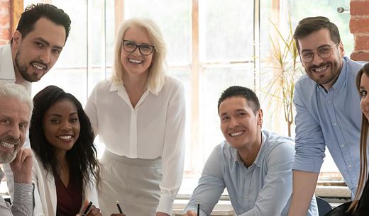 Multi generational employees sitting around a table.