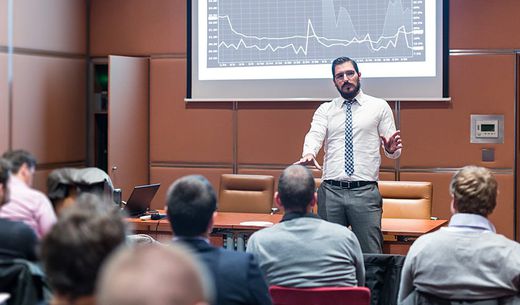 Man presenting data to a full room.