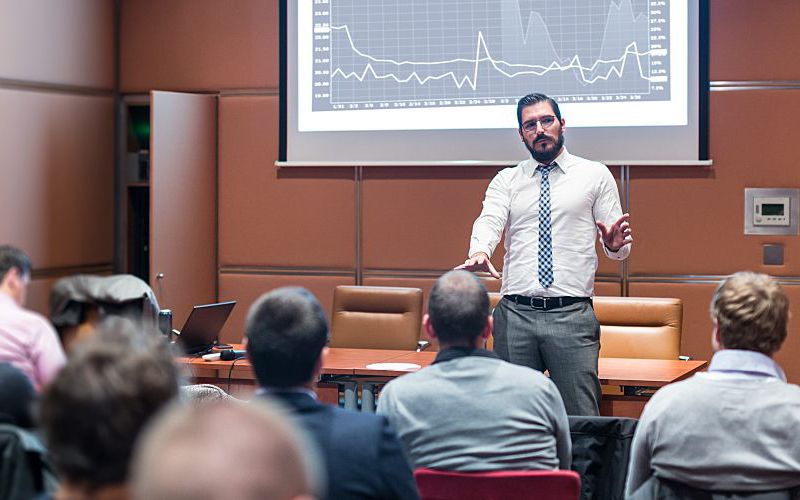 Man presenting data to a full room.