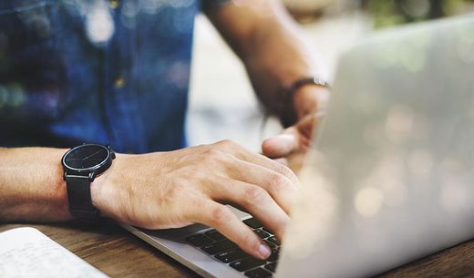 Man sitting working on a laptop computer.