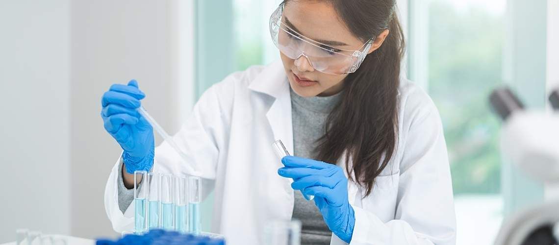 A researcher using a pipette in a lab.