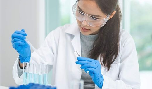 A researcher using a pipette in a lab.