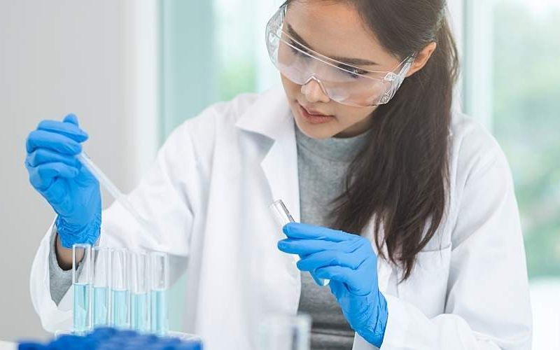 A researcher using a pipette in a lab.