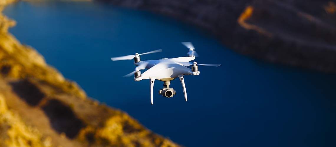 A drone with a digital camera above water.