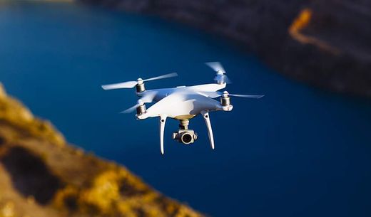 A drone with a digital camera above water.