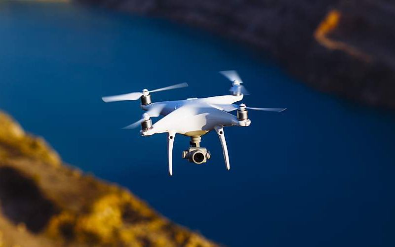 A drone with a digital camera above water.