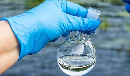 A citizen scientist takes water samples from a river.