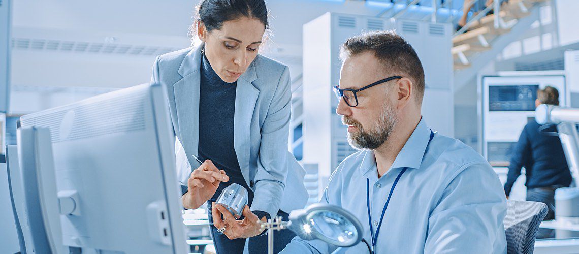 A lab manager explains a new tool to a co-worker.