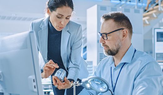 A lab manager explains a new tool to a co-worker.