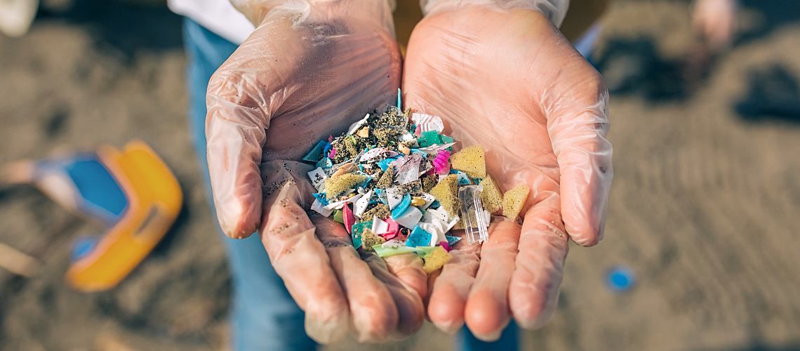Person holds microplastics of different shapes and sizes in their hands.