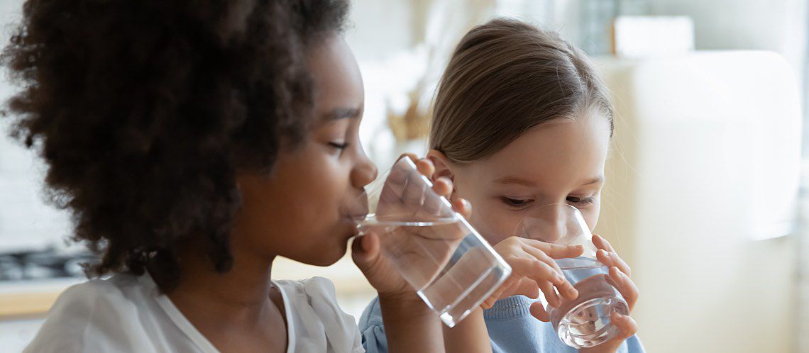 Two children drink water that meets the EPA water quality standards.