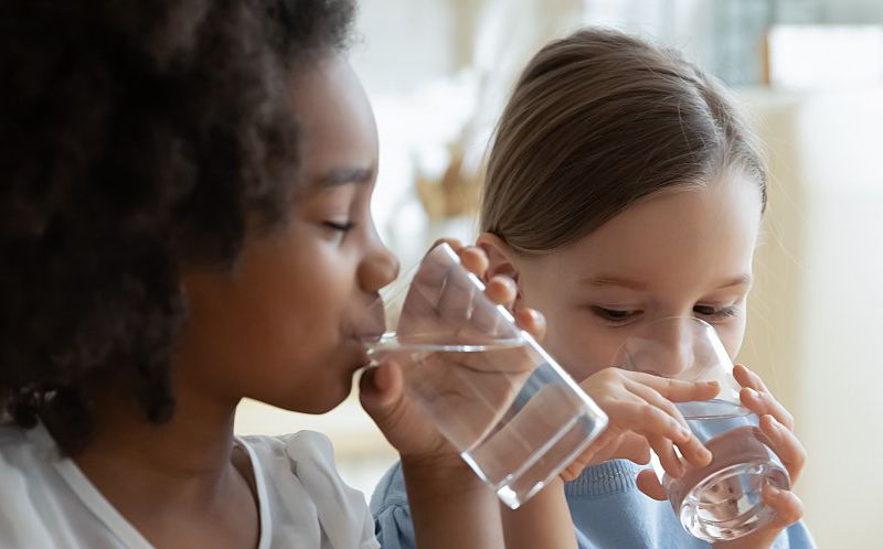 Two children drink water that meets the EPA water quality standards.