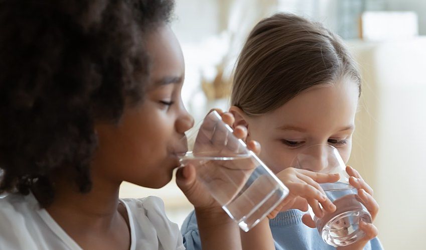 Two children drink water that meets the EPA water quality standards.