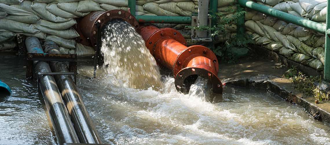 A wastewater pipe overflows due to flooding