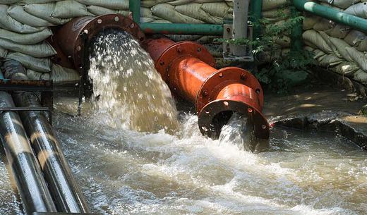 A wastewater pipe overflows due to flooding