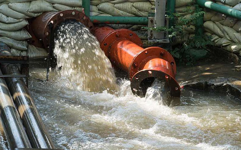 A wastewater pipe overflows due to flooding