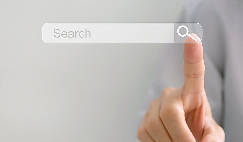 A person taps a search icon with their finger.