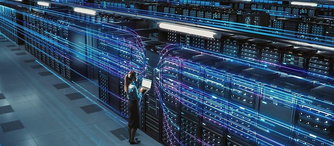 A technician stands in front of thirsty servers in data center.