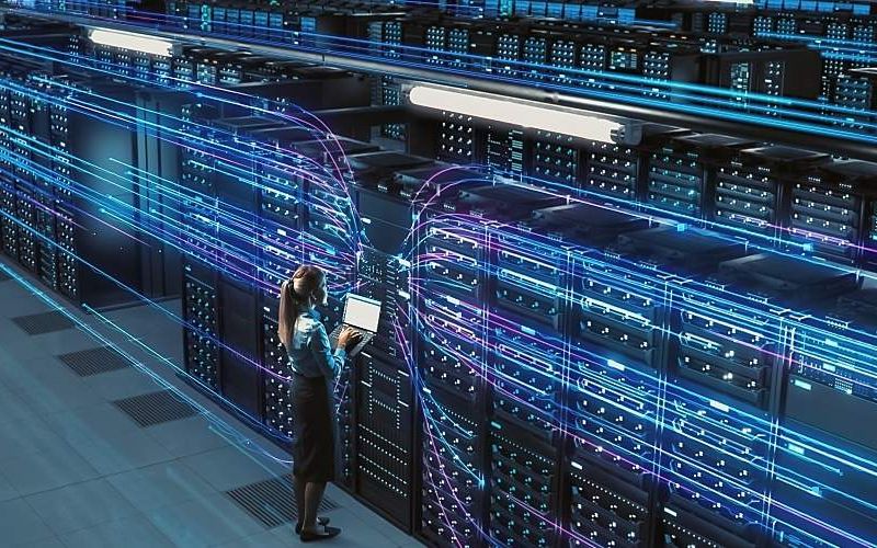 A technician stands in front of thirsty servers in data center.