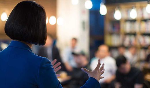 Woman presenting to a group of colleagues.
