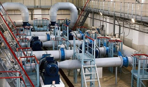 An industrial water pumping station with pumps, pipes, and valves.