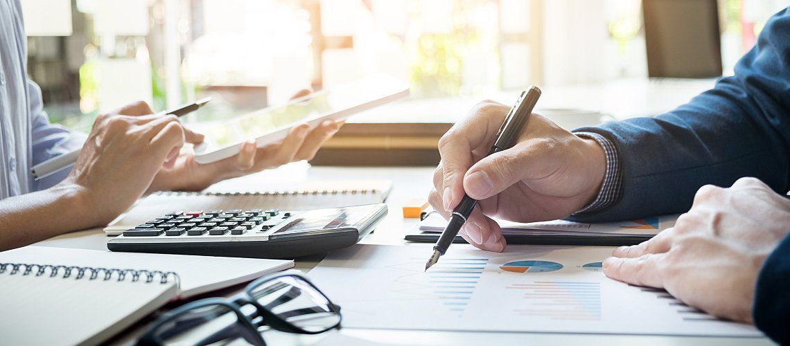 Two employees sitting at a work table working on company budget.