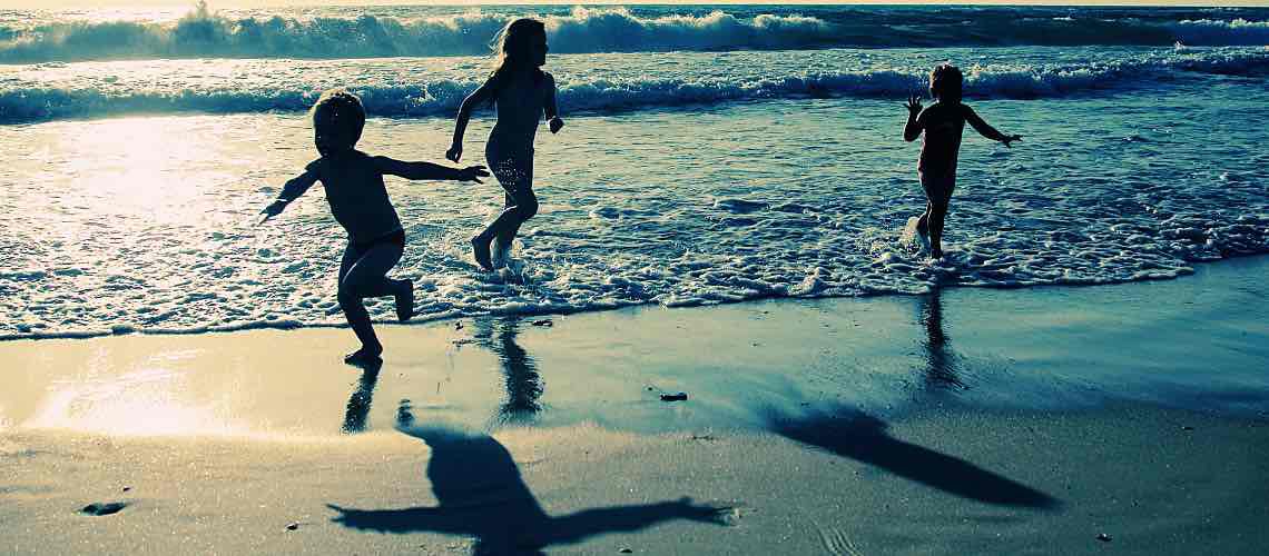 Children at beach at sunset.