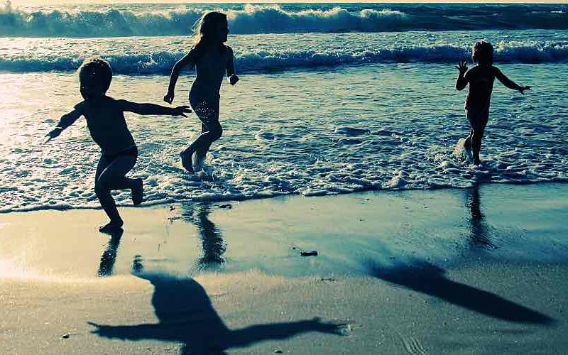 Children at beach at sunset.