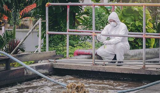 Scientist conducts wastewater sampling to detect pathogens for infectious diseases.