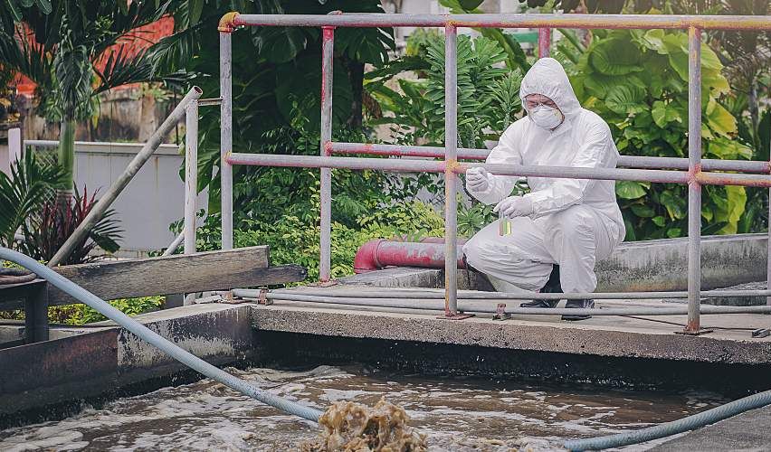Scientist conducts wastewater sampling to detect pathogens for infectious diseases.