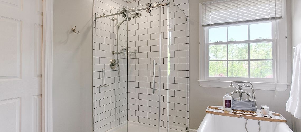 A modern bathroom with glass shower.