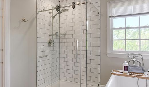 A modern bathroom with glass shower.