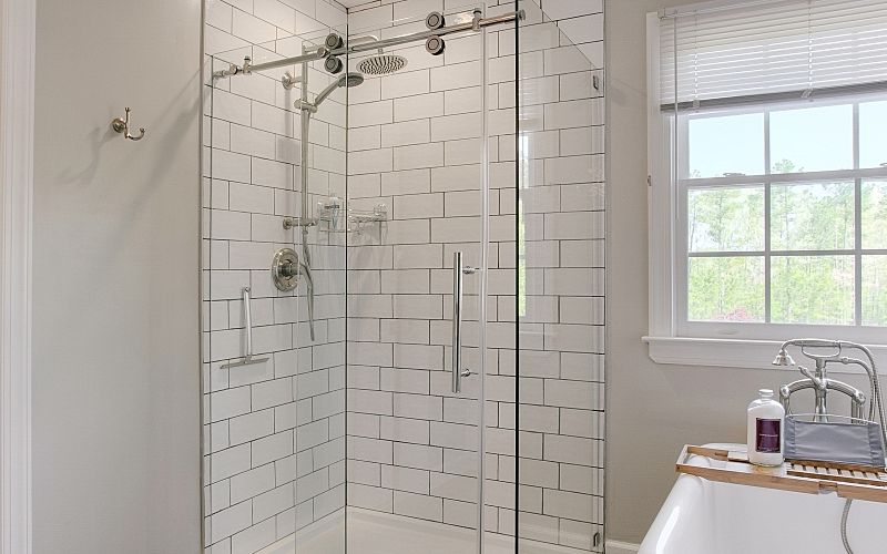 A modern bathroom with glass shower.