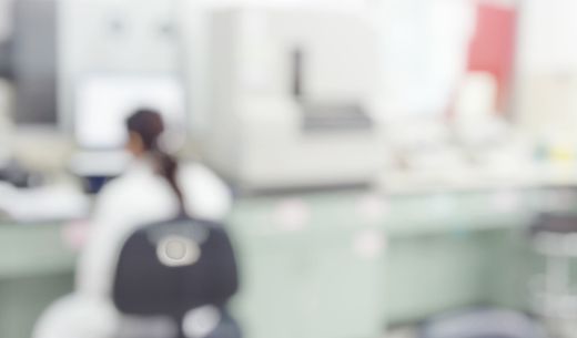 Woman sitting work at a work bench in a laboratory.