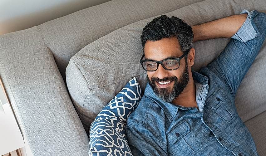 Man relaxes at home while using paid time off.