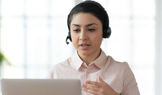 Person wearing a headset hosting a webinar from their home office.