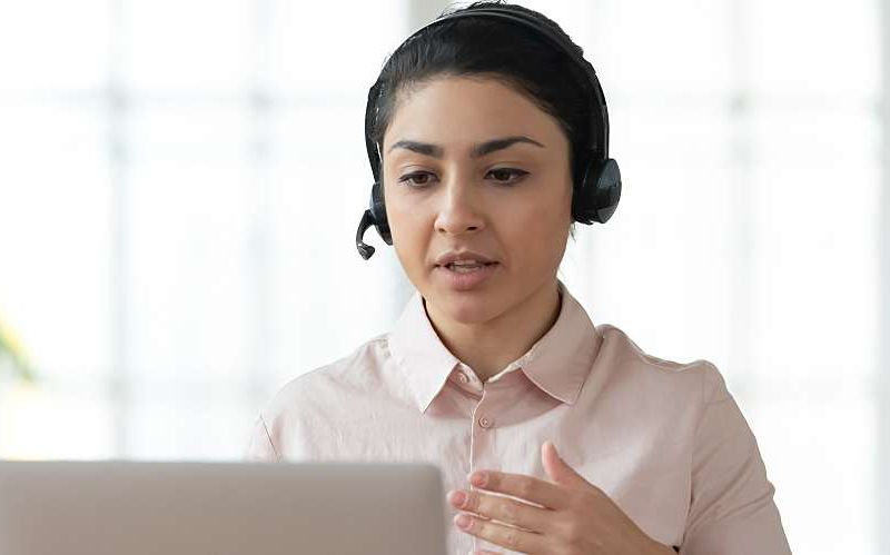 Person wearing a headset hosting a webinar from their home office.