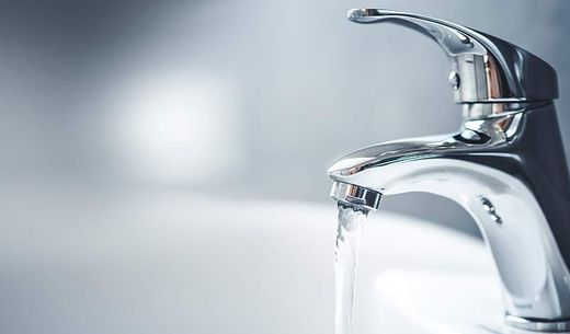 A bathroom tap with flowing water.