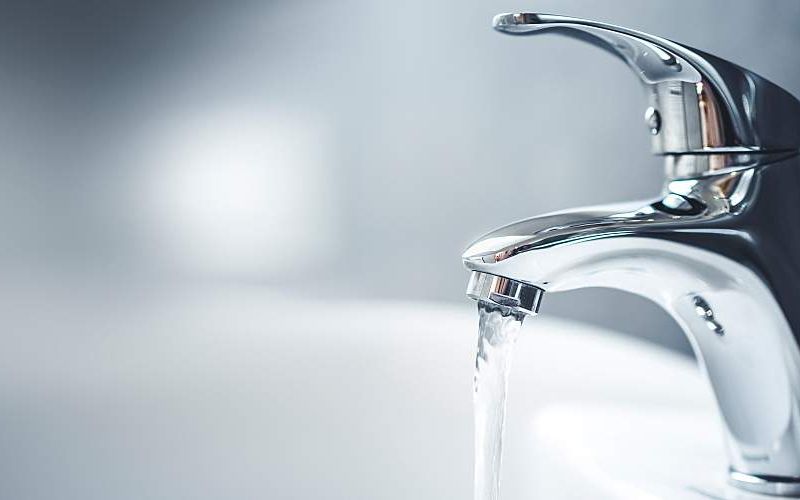 A bathroom tap with flowing water.