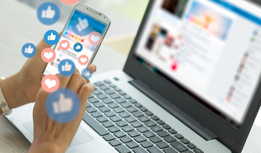 An employee uses social media on a phone and a laptop