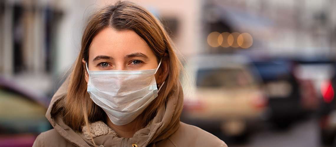 Woman wearing a mask in a city.