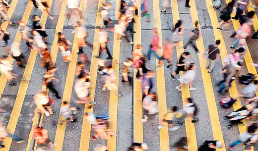 Large crowd of people crossing a busy street.