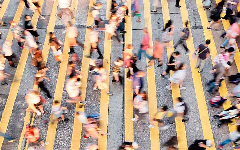 Large crowd of people crossing a busy street.