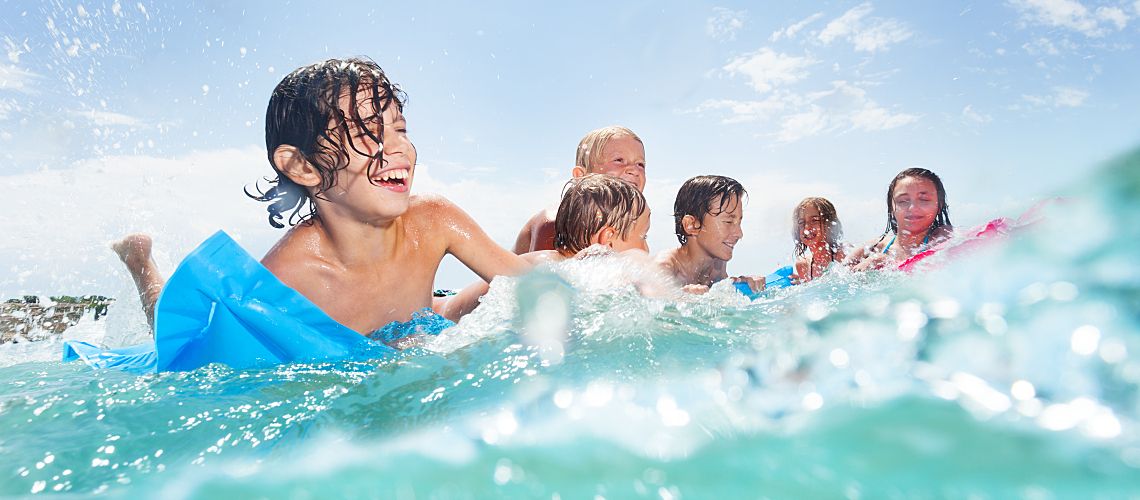 A group of people smiling while swimming in the ocean.