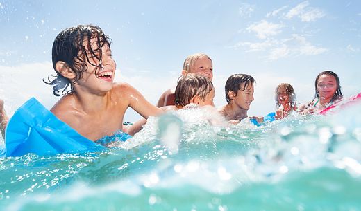 A group of people smiling while swimming in the ocean.